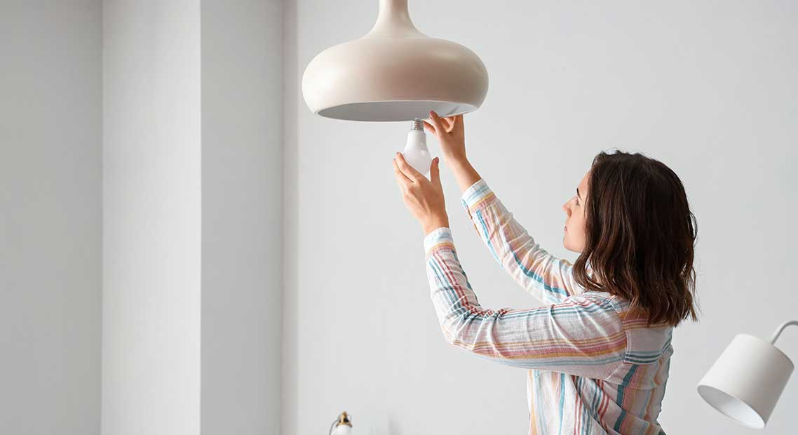 Interior Energy Usage programs image - person installing LED light bulb